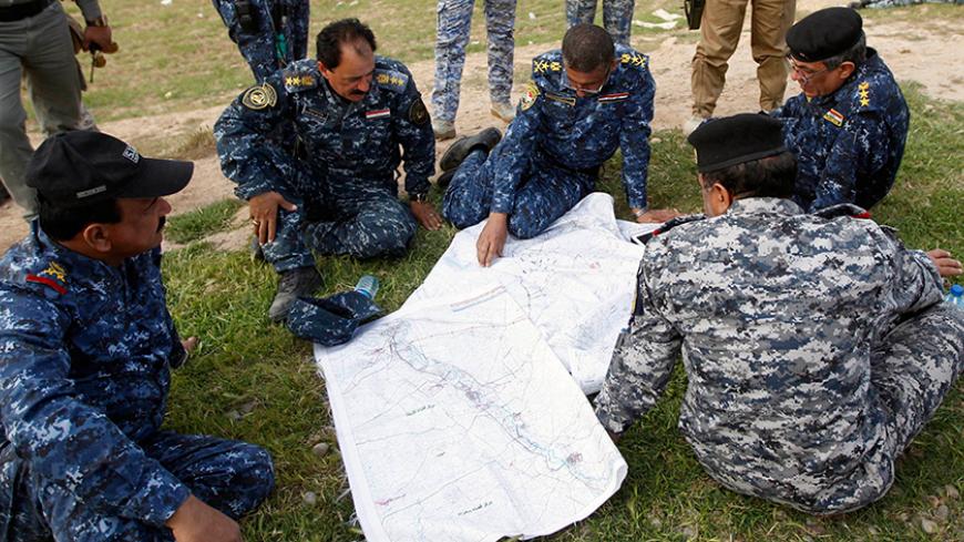Iraqi officers inspect a map on the outskirts of al-Alam March 8, 2015. REUTERS/Thaier Al-Sudani (IRAQ - Tags: MILITARY CIVIL UNREST CONFLICT)



Thaier Al-Sudani: "It was me and a few other Iraqi journalists working for local outlets. We went to the frontlines in coordination with the Iraqi government forces and supporting militias.
 
The press officer would come in the morning and take us to the frontline in a convoy.
 
Whenever an area was won from Islamic State, the fighters would chant and pray and sho