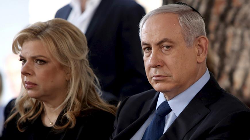 Israeli Prime Minister Benjamin Netanyahu sits with his wife Sara during the state funeral ceremony of Israel's former president Yitzhak Navon at the Mt. Herzl Cemetery in Jerusalem November 8, 2015.  REUTERS/Gali Tibbon/Pool - RTS612E