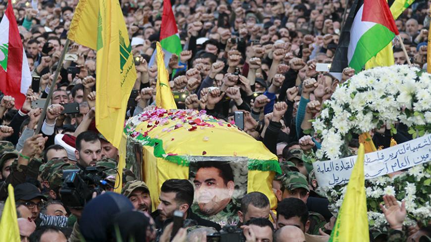 Hezbollah members carry the coffin of Hezbollah militant leader Samir Qantar, as supporters wave Lebanese, Palestinian and Hezbollah flags, during his funeral in Beirut's southern suburbs, Lebanon December 21, 2015. REUTERS/Aziz Taher - RTX1ZMHA