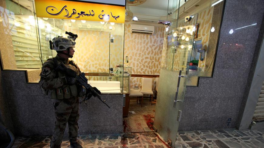An Iraqi soldier stands guard near a goldsmith's shop after an attack during a robbery in Baghdad October 17, 2010. At least 12 people died when gunmen swooped down on a row of goldsmiths' shops in a brazen midday robbery in the Iraqi capital on Sunday and ended up in a gunfight with security forces, police and military sources said. REUTERS/Saad Shalash (IRAQ - Tags: CONFLICT MILITARY CRIME LAW IMAGES OF THE DAY) - RTXTJ7I