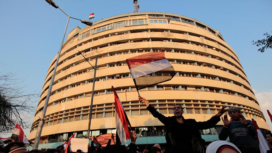 Anti-government protesters wave flags in front of the state TV building on the Corniche in Cairo February 11, 2011. A furious wave of protest finally swept Egypt's President Hosni Mubarak from power on Friday after 30 years of one-man rule, sparking jubilation on the streets and sending a warning to autocrats across the Arab world and beyond. REUTERS/Dylan Martinez (EGYPT - Tags: POLITICS CIVIL UNREST) - RTXXQZZ