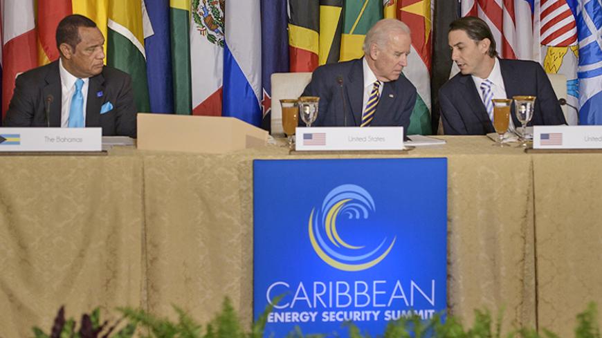 Bahamas Prime Minister Perry Christie (L) looks on as US Vice President Joseph R. Biden (C) and Amos J. Hochstein, US State Department Special Envoy and Coordinator for International Energy Affairs, talk before the Caribbean Energy Security Initiative Luncheon during the Caribbean Energy Security Summit at the US Department of States January 26, 2015 in Washington, DC.  Leaders from around the Caribbean attended the summit to discuss energy and regional issues. AFP PHOTO/BRENDAN SMIALOWSKI        (Photo cre