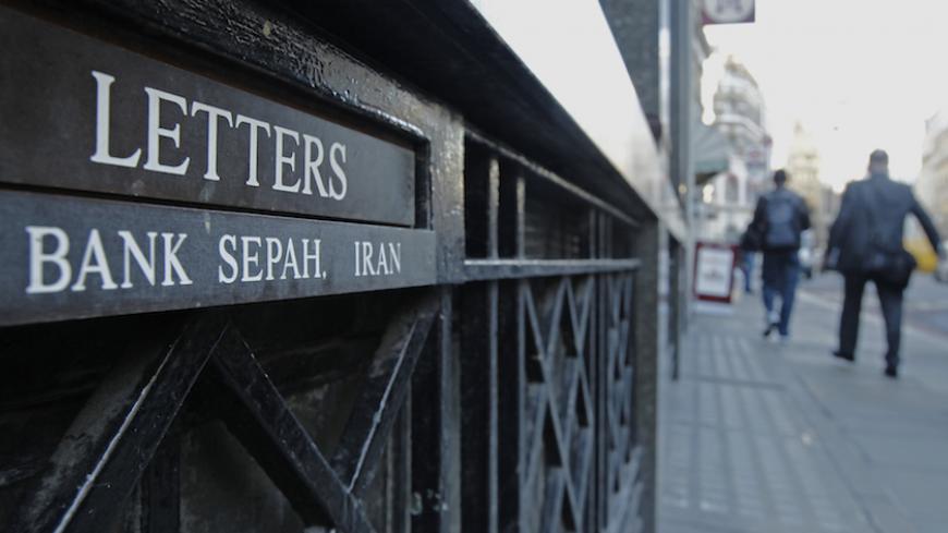 People pass the letterbox of Iranian owned Bank Sepah International in London December 22, 2011. Saderat is one of a handful of lonely Iranian banking outposts that have managed to hold out in Europe's financial hub despite escalating tensions with the West over Iran's nuclear programme.  REUTERS/Luke MacGregor  (BRITAIN - Tags: BUSINESS POLITICS) - RTR2VJUY