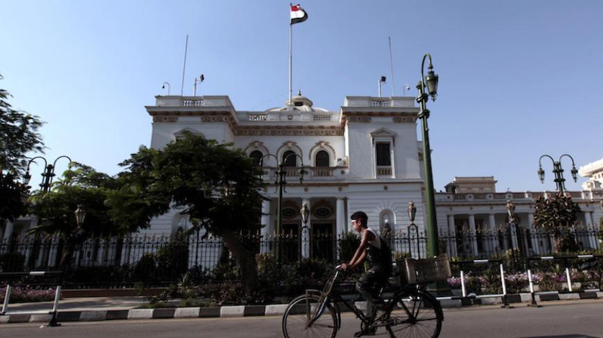 A boy rides a bike in front of the parliament building in Cairo, June 14, 2012. In a setback for Islamists, a court declared that rules in the post-Mubarak parliamentary election that handed control to Islamists were unconstitutional. The head of the court said the lower house would have to be dissolved. REUTERS/Mohamed Abd El-Ghany (EGYPT - Tags: POLITICS) - RTR33M20