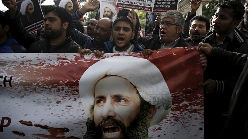 Shi'ite Muslims living in Greece hold pictures of Shi'ite cleric Sheikh Nimr al-Nimr and shout slogans during a demonstration against his execution in Saudi Arabia, outside the embassy of Saudi Arabia in Athens, Greece, January 6, 2016. REUTERS/Alkis Konstantinidis - RTX219TK
