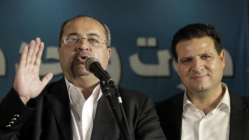 Israeli-Arab candidate who is member of a Joint List of Arab parties Ahmad Tibi (L) delivers a speech next to Israeli Arab political leader and leader of the joint list of Arab parties, Ayman Odeh, at the party's headquarters in the city of Nazareth on March 17, 2015 as they react to exit poll figures. The Joint List grouping Israel's main Arab parties took third place in Tuesday's general election, winning 13 seats, exit polls showed. AFP PHOTO / AHMAD GHARABLI        (Photo credit should read AHMAD GHARAB