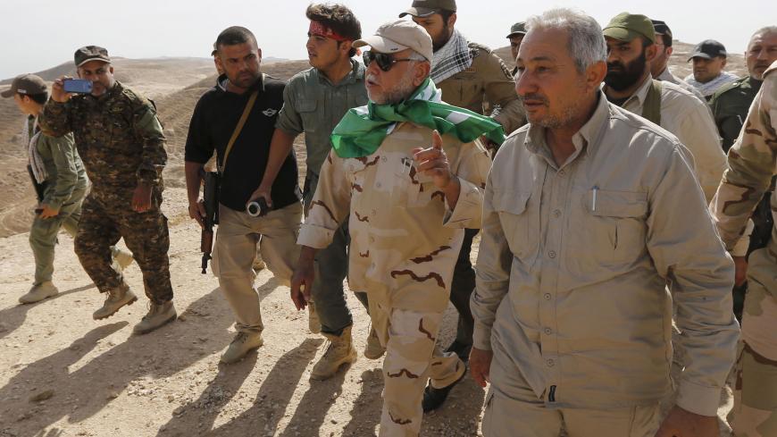 Head of the Badr Organisation Hadi al-Amiri (C) walks with Shi'ite fighters in Makhoul mountains, north of Baiji, October 17, 2015. Iraqi forces and Shi'ite militia fighters recaptured most of the country’s largest oil refinery from Islamic State militants on Thursday, security officials said. The report could not be independently confirmed because it is too dangerous for journalists to enter the battle zone around the refinery near the town of Baiji, about 190 km (120 miles) north of Baghdad. REUTERS/Thaie