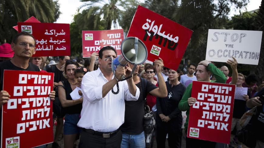 Ayman Odeh (C), leader of the Joint Arab list, and Dov Khenin (L), a fellow party member and member of parliament, take part in a left-wing protest in light of recent Palestinian-Israeli violence in Tel Aviv, Israel October 9, 2015. In the past 10 days, four Israelis have been shot or stabbed to death in Jerusalem and the occupied West Bank, and at least a dozen have been wounded by Palestinians wielding knives or screwdrivers in stabbings in Tel Aviv and other Israeli cities. Three Palestinians have also b