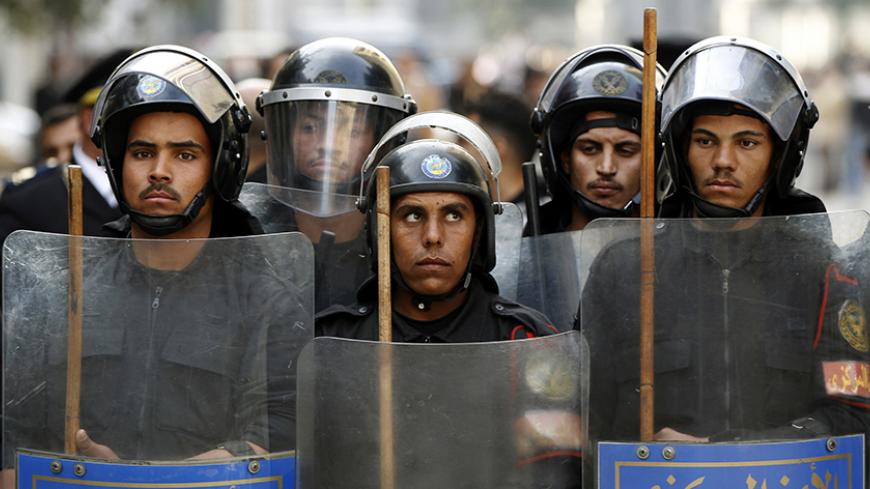 Riot police keep watch as they hold shields during clashes with protesters in Cairo January 26, 2011. Thousands of Egyptians defied a ban on protests by returning to Egypt's streets on Wednesday and calling for President Hosni Mubarak to leave office, and some scuffled with police. REUTERS/Goran Tomasevic (EGYPT - Tags: CIVIL UNREST POLITICS) FOR BEST QUALITY IMAGE SEE GF2EA940PG401 - RTXX3VG