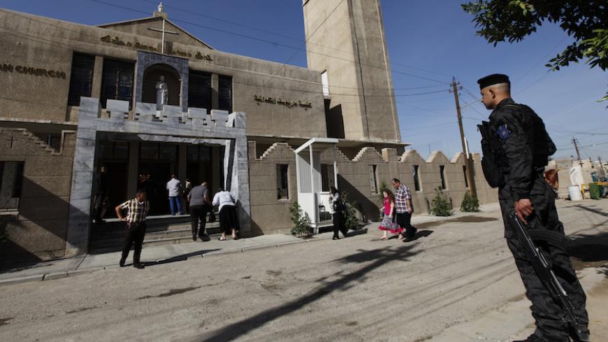 An Iraqi policeman stands guard as people enter the St. Joseph Chaldean Church for an Easter mass in Baghdad March 31, 2013. REUTERS/Mohammed Ameen (IRAQ - Tags: SOCIETY RELIGION) - RTXY3QW