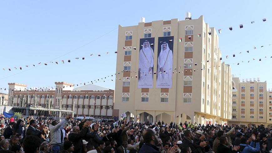 Posters depicting Qatar's former Emir Sheikh Hamad bin Khalifa al-Thani (R) and Emir of Qatar Tamim bin Hamad al-Thani are seen on a building as people attend the opening ceremony of Qatari-funded construction project "Hamad City", in Khan Younis in the southern Gaza Strip January 16, 2016.     REUTERS/Ibraheem Abu Mustafa  - RTX22NTA
