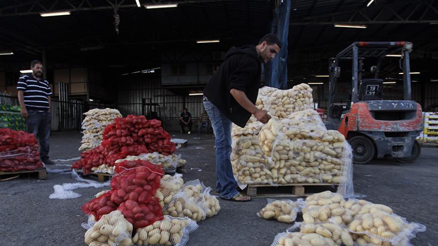 A worker arranges sacks of potatoes on a pallet at a wholesale vegetable and fruit market in the West Bank village of Beita, near Nablus September 2, 2012.Once the mainstay of the local economy, Palestinian agriculture in the rocky West Bank is in decline, with farmers struggling to protect both their livelihoods and their lands. Deprived of water and cut off from key markets, farmers across the occupied territory can only look on with a mix of anger and envy as Israeli settlers copiously irrigate their own