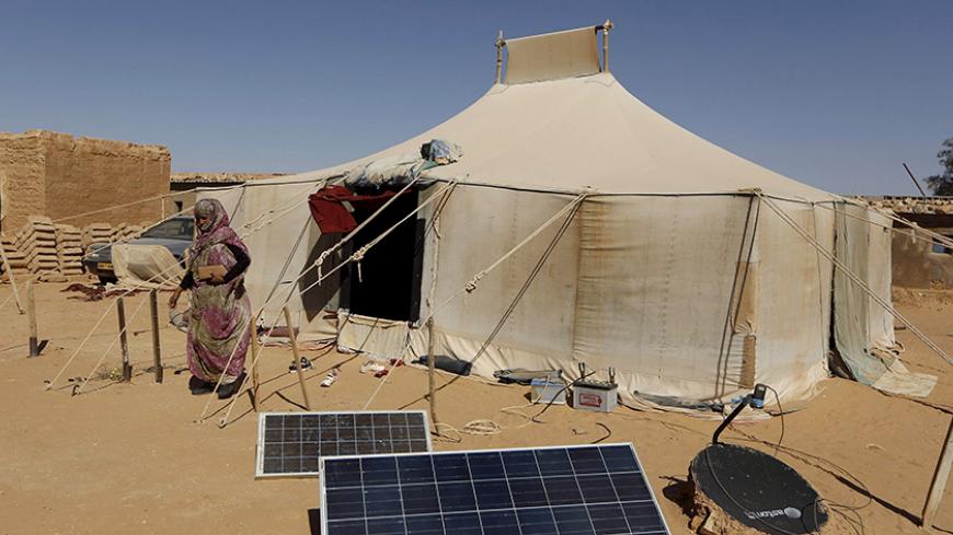 An indigenous Sahrawi woman walks outside her tent in Al Smara desert refugee camp in Tindouf, southern Algeria March 4, 2016. In refugee camps near the town of Tindouf in arid southern Algeria, conditions are hard for indigenous Sahrawi residents. Residents use car batteries for electricity at night and depend on humanitarian aid to get by. The five camps near Tindouf are home to an estimated 165,000 Sahrawi refugees from the disputed region of Western Sahara, according to the United Nations refugee agency