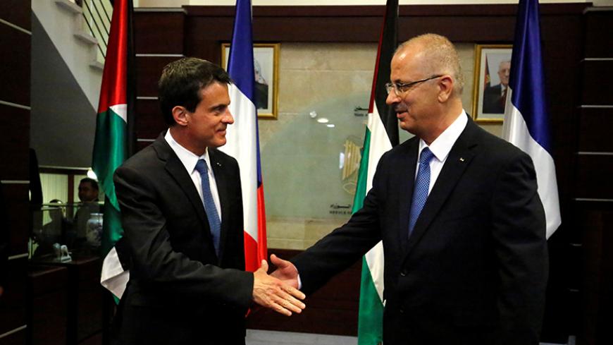 Palestinian Prime Minister Rami Hamdallah (R) shakes hands with French Prime Minister Manuel Valls before their meeting in the West Bank city of Ramallah May 24, 2016. REUTERS/ABBAS MOMANI/Pool - RTSFOQ3