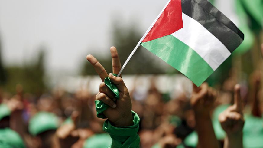 A student supporting Hamas holds a Palestinian flag in a rally during an election campaign for the student council at the Birzeit University in the West Bank city of Ramallah April 26, 2016. REUTERS/Mohamad Torokman  - RTX2BOVO