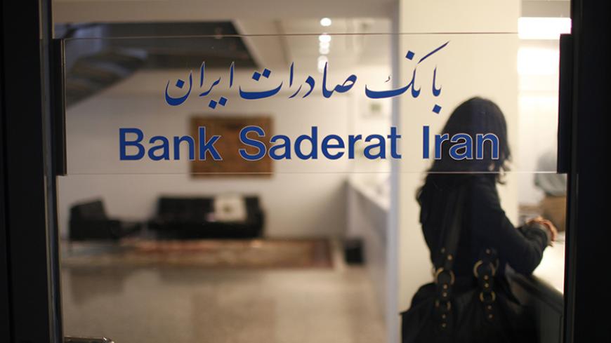 A woman waits behind the entrance door of the German branch of the Bank Saderat Iran in the northern German town of Hamburg August 18, 2010. Picture taken August 18, 2010.    REUTERS/Christian Charisius (GERMANY - Tags: BUSINESS) - RTR2HPYU