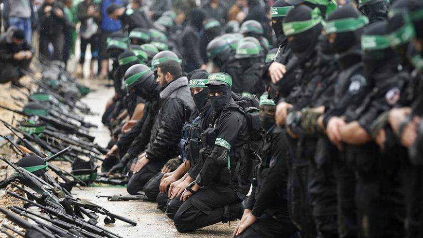 Palestinian members of al-Qassam Brigades, the armed wing of the Hamas movement, pray before a military parade marking the 27th anniversary of Hamas' founding, in Gaza City December 14, 2014.  REUTERS/Mohammed Salem (GAZA - Tags: POLITICS MILITARY ANNIVERSARY RELIGION) - RTR4HY0R