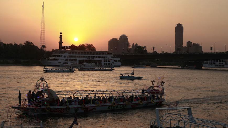 People sit in a boat on the river Nile in Cairo June 15, 2012. The Muslim Brotherhood's Mohamed Morsy is tempering forecasts of victory in Egypt's presidential election with a warning that vote rigging typical of the Hosni Mubarak era may hand victory to Ahmed Shafik, the deposed leader's last prime minister.   REUTERS/Suhaib Salem (EGYPT - Tags: POLITICS ELECTIONS) - RTR33O5K