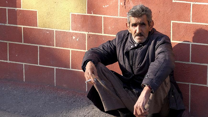 An unemployed labourer smokes a cigarette as he waits for a job offer on a sidewalk in Tehran, Iran January 20, 2016. REUTERS/Raheb Homavandi/TIMA  ATTENTION EDITORS - THIS IMAGE WAS PROVIDED BY A THIRD PARTY. FOR EDITORIAL USE ONLY.   - RTX238JA
