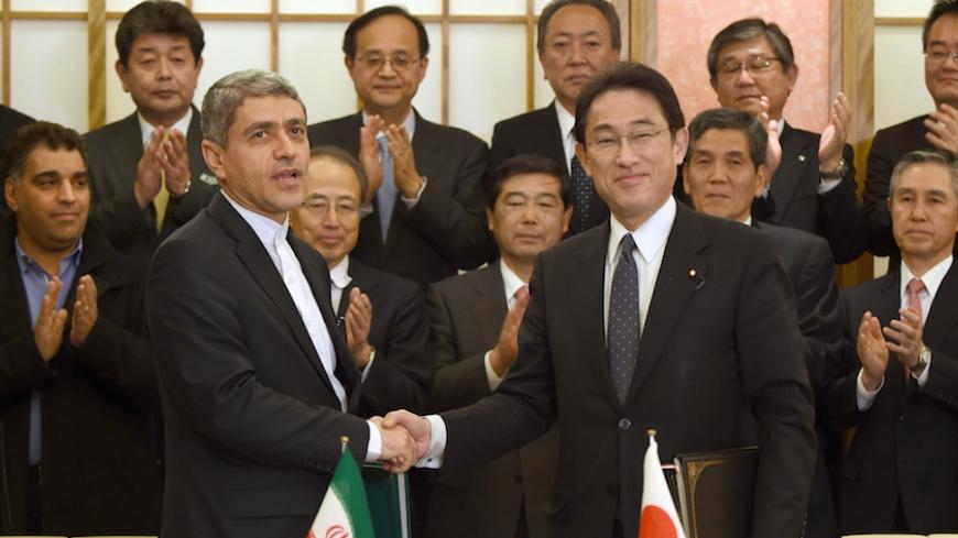 Japanese Foreign Minister Fumio Kishida (front R) shakes hands with Iranian Economic and Finance Minister Ali Tayebnia (front L) during their signing ceremony for an investment agreement between the two countries in front of Japanese and Iranian business persons at the Foreign Ministry in Tokyo February 5, 2016. Tayebnia is here on a five-day visit to Japan. REUTERS/Toru Yamanaka/Pool  - RTX25JZJ