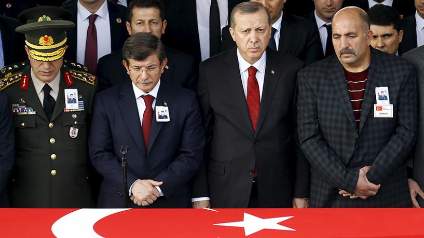 Turkish President Tayyip Erdogan (2nd R), Chief of Staff General Hulusi Akar (L), Prime Minister Ahmet Davutoglu (2nd L) and the father Ali Cil (R) stand behind the flag-draped coffin of Army officer Seckin Cil during a funeral ceremony in Ankara, Turkey, February 18, 2016. Army officer Seckin Cil was killed during the clashes between Turkish security forces and Kurdish militants in Sur district of the southeastern city of Diyarbakir. REUTERS/Umit Bektas - RTX27ISS