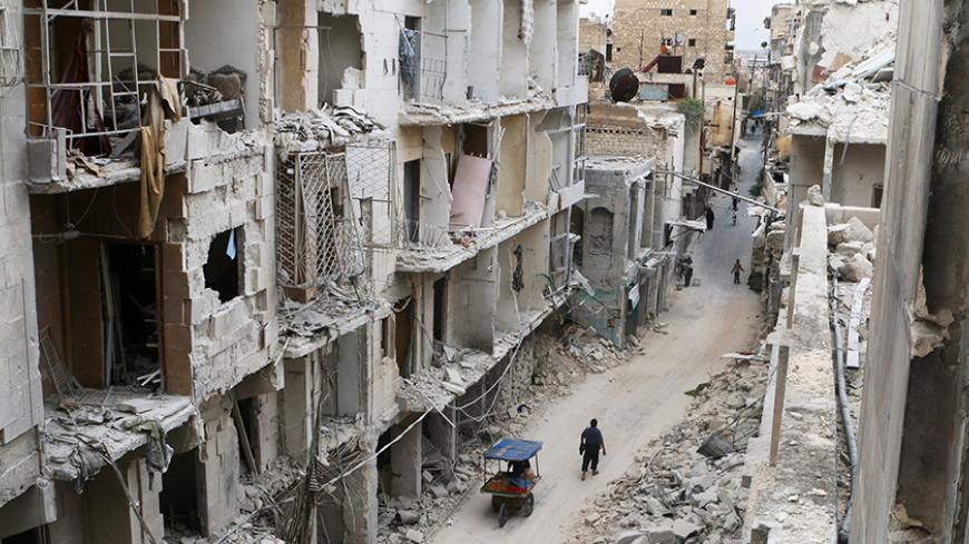 Residents walk near damaged buildings in the rebel held area of Old Aleppo, Syria May 5, 2016. REUTERS/Abdalrhman Ismail/File Photo - RTX2FSH5