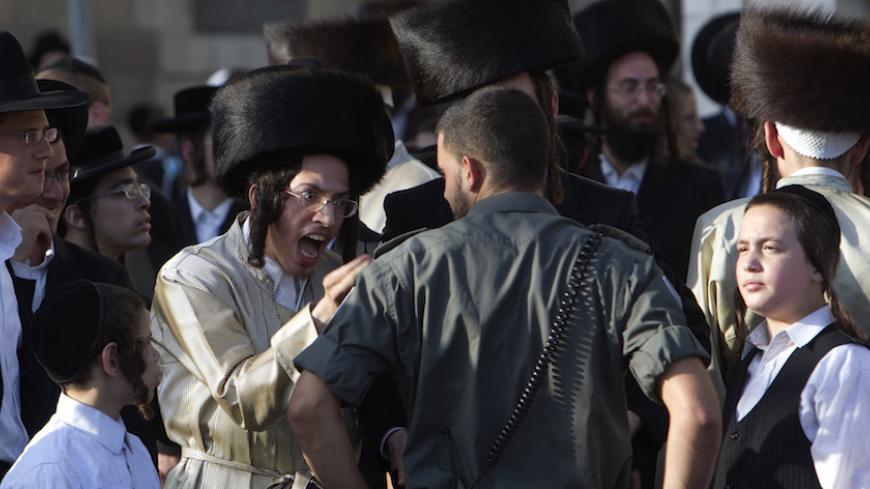 An ultra-Orthodox Jew shouts at a policeman during a protest against the opening of a road on the Sabbath, near a religious neighborhood in Jerusalem July 30, 2011. REUTERS/Ronen Zvulun (JERUSALEM - Tags: RELIGION CIVIL UNREST IMAGES OF THE DAY) - RTR2PGWG