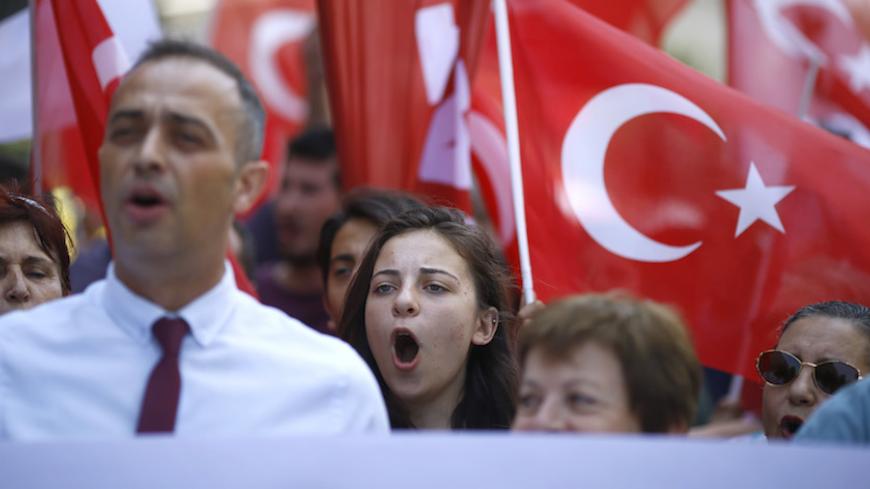 Demonstrators wave Turkish flags as they shout slogans demanding the extradition of U.S.-based cleric Fethullah Gulen, whom the Turkish government blame for a failed coup attempt last week, during a protest near the U.S. Embassy in Ankara, Turkey, July 19, 2016. REUTERS/Osman Orsal - RTSIOIV