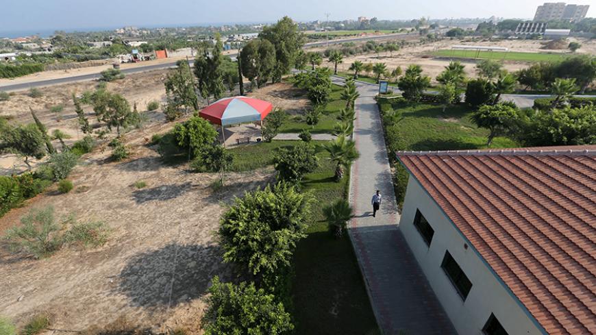 A Palestinian security guard walks at a university built on the former Jewish settlement of Neve Dekalim, in Khan Younis in the southern Gaza Strip August 6, 2015. Picture taken August 6, 2015. To match Insight ISRAEL-GAZA/DISENGAGEMENT.     REUTERS/Ibraheem Abu Mustafa - RTX1NSI8