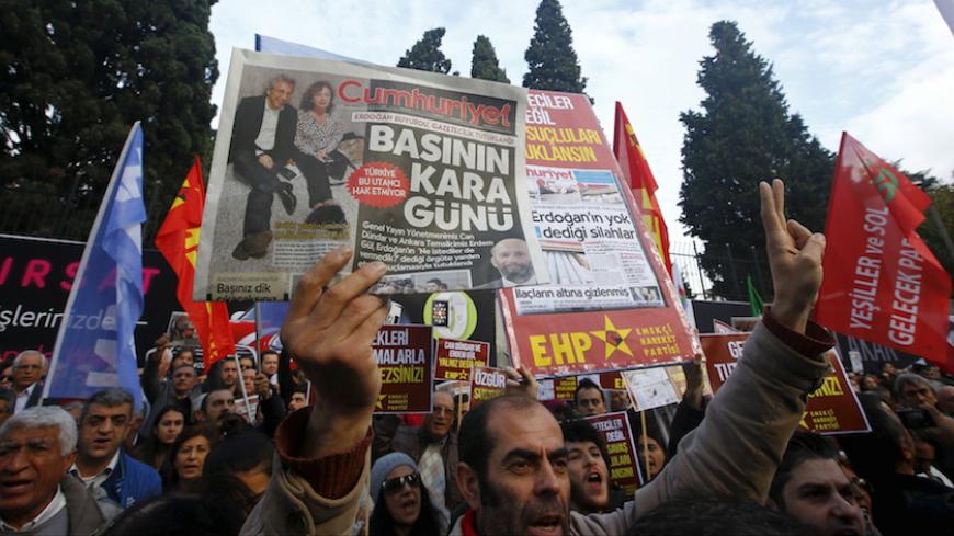 A demonstrator holds newspaper read "Black day of the press" during a protest outside the Cumhuriyet newspaper in Istanbul, Turkey, November 27, 2015.  Around 2,000 people protested on Friday over the arrest of two prominent journalists on charges of espionage and terrorist propaganda, a case that has revived long-standing criticism of Turkey's record on press freedom under President Tayyip Erdogan. REUTERS/Osman Orsal  - RTX1W3XS