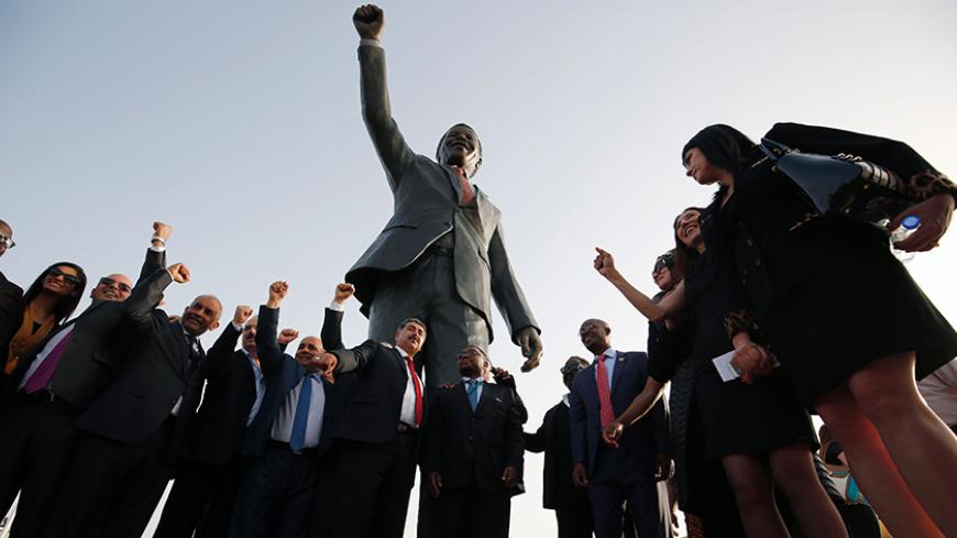 Palestinian and South African officials pose in front of a giant statue of Nelson Mandela during its inauguration ceremony in the West Bank city of Ramallah on April 26, 2016.
Palestinians inaugurated the statue of Mandela donated by the South African city of Johannesburg to their political capital. The six-metre (20-foot) two-tonne bronze statue was a gift from Johannesburg with which Ramallah is twinned.

 / AFP / ABBAS MOMANI        (Photo credit should read ABBAS MOMANI/AFP/Getty Images)