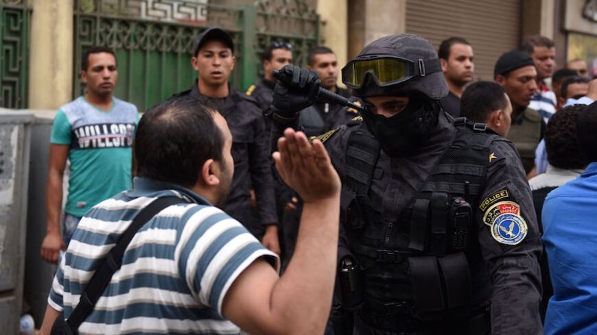 A journalist scuffles with a policeman during a protest to demand the sacking of the interior minister on May 4, 2016 outside the Journalists' Syndicate headquarters in Cairo, after an unprecedented police raid to arrest two reporters.
Egyptian police stormed the headquarters of the journalists' association in central Cairo on May 1, 2016  and arrested two journalists, Amr Badr and Mahmud el-Sakka, for incitement to protest. / AFP / MOHAMED EL-SHAHED        (Photo credit should read MOHAMED EL-SHAHED/AFP/Ge