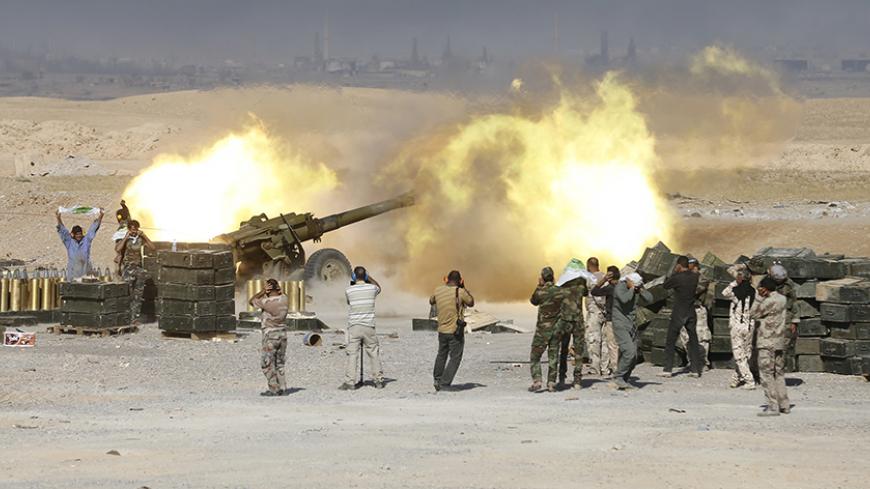 Shi'ite fighters launch artillery toward Islamic State militants in al-Fatha, northeast of Baiji, October 18, 2015. Iraqi forces backed by Shi'ite militia fighters say they have retaken a mountain palace complex of former President Saddam Hussein from Islamic State fighters, as government forces push ahead on a major offensive against the insurgents.  REUTERS/Thaier Al-Sudani       TPX IMAGES OF THE DAY      - RTS4YZX