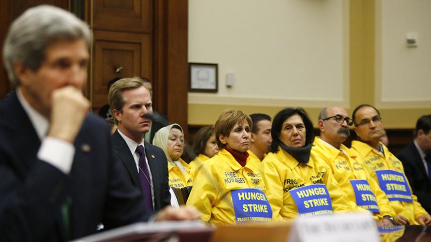The U.S. families of Iranian dissidents, members of Iran's opposition movement Mujahedin-e Khalq (MEK) who reside in Camp Liberty in Iraq, look on as U.S. Secretary of State John Kerry testifies on agreements over Iran's nuclear programs, before the House Foreign Affairs Committee on Capitol Hill in Washington, December 10, 2013. REUTERS/Jonathan Ernst    (UNITED STATES - Tags: POLITICS MILITARY) - RTX16CNF