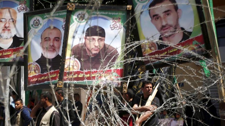 Pictures of Palestinian Hamas militants held in Israeli jails are seen through a fence during a rally marking Palestinian Prisoner Day, in Gaza City April 17, 2016. REUTERS/Mohammed Salem - RTX2AAQR