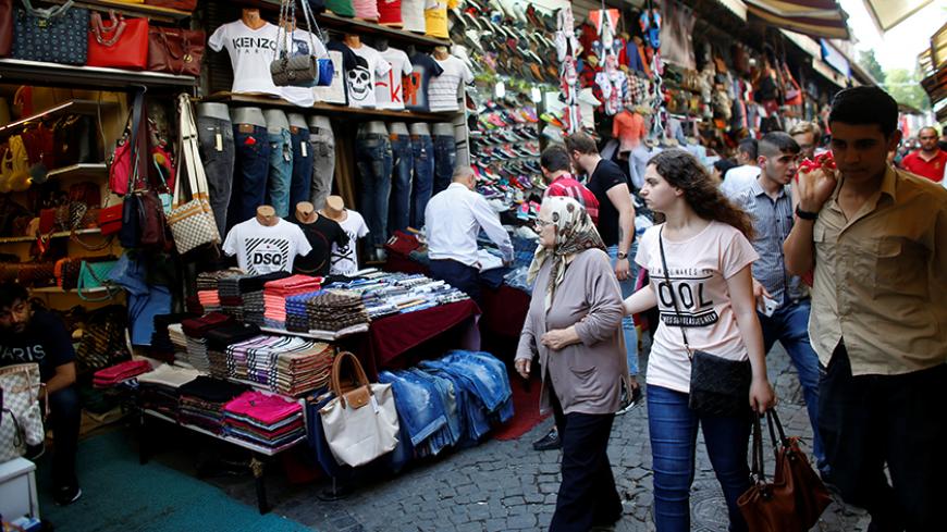 Women walk past by shops at an open air bazaar near the Grand Bazaar, known as the Covered Bazaar, in Istanbul, Turkey, June 14, 2016. REUTERS/Murad Sezer - RTX2G65X