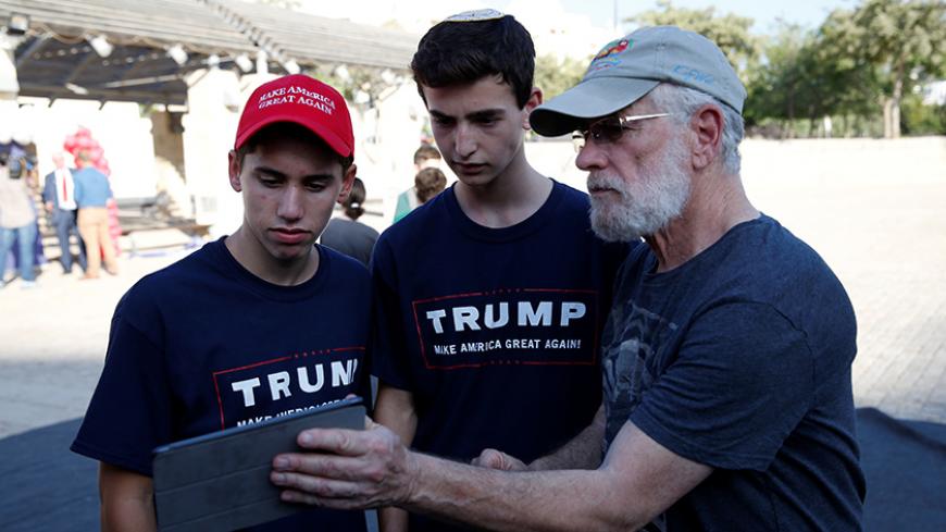 Israeli American Sruly Cooper(R) signs to vote in the US elections in front of members of the U.S. Republican party's election campaign team in Israel during a campaign aimed at potential American voters living in Israel, near a mall in Modi'in, Israel August 15, 2016. REUTERS/Baz Ratner  - RTX2KZVI