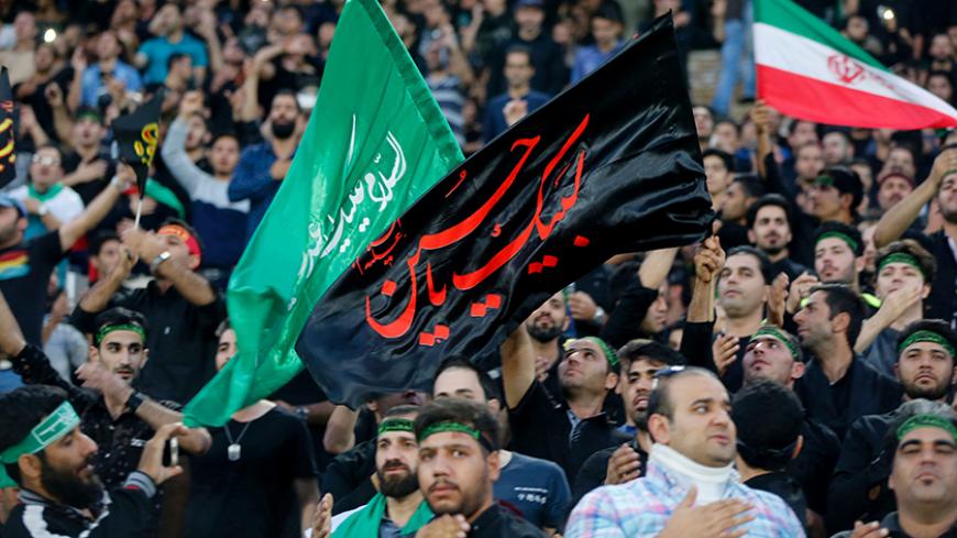 Iranian fans wave a religious banner to mark Ashura, which marks the death of Prophet Mohammed's grandson Imam Hussein in the seventh century, during the 2018 World Cup qualifying football match between Iran and South Korea at the Azadi Stadium in Tehran on October 11, 2016. / AFP / ATTA KENARE        (Photo credit should read ATTA KENARE/AFP/Getty Images)