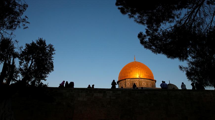Palestinians are silhouetted as they walk in front of the Dome of the Rock on the compound known to Muslims as al-Haram al-Sharif and to Jews as Temple Mount in Jerusalem's Old City, before the start of morning prayers marking the first day of Eid al-Adha celebrations, early morning September 12, 2016. REUTERS/Ammar Awad - RTSNCVX