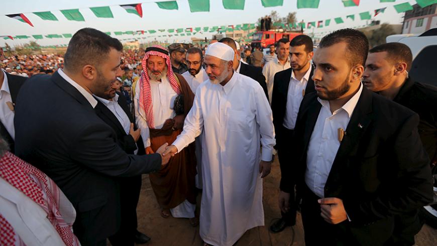 Senior Hamas leader Ismail Haniyeh (C) shakes hands with a man as he arrives to lead Eid al-Adha prayer in Khan Younis in the southern Gaza Strip September 24, 2015. Muslims across the world celebrate the annual festival of Eid al-Adha or the Feast of the Sacrifice, which marks the end of the annual haj pilgrimage, by slaughtering goats, sheep, cows and camels in commemoration of the Prophet Abraham's readiness to sacrifice his son to show obedience to Allah.  REUTERS/Ibraheem Abu Mustafa - RTX1S6G2