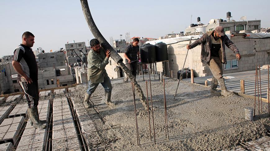 Palestinian workers pour cement on the roof of a building under construction in the southern Gaza Strip town of Rafah, on April 5, 2016.
Israel, earlier in the week, announced it had stopped private imports of cement to the Hamas-run Palestinian enclave, accusing Imad al-Baz, deputy director of the economy ministry, of diverting supplies. / AFP / SAID KHATIB        (Photo credit should read SAID KHATIB/AFP/Getty Images)