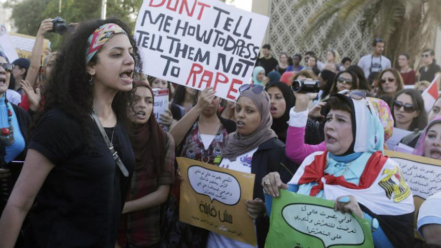 Women chant slogans as they gather to protest against sexual harassment in front of the opera house in Cairo June 14, 2014, after a woman was sexually assaulted by a mob during the June 8 celebrations marking the new president Abdel Fattah al-Sisi's inauguration in Tahrir square. Egypt has asked YouTube to remove a video showing the naked woman with injuries being dragged through the square after being sexually assaulted during the celebrations. Authorities have arrested seven men aged between 15 and 49 for