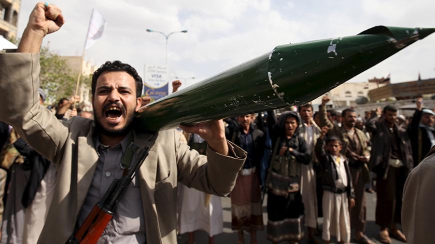A Houthi follower carries a mock missile as he shouts slogans during a demonstration against the United Nations in Sanaa, Yemen, July 5, 2015. Hundreds of supporters of the Iran-backed Houthi rebels took to the streets of the Yemeni capital on Sunday to protest against the United Nations and its alleged support of Yemen's exiled President Abd-Rabbu Mansour Hadi. REUTERS/Mohamed al-Sayaghi - RTX1J485