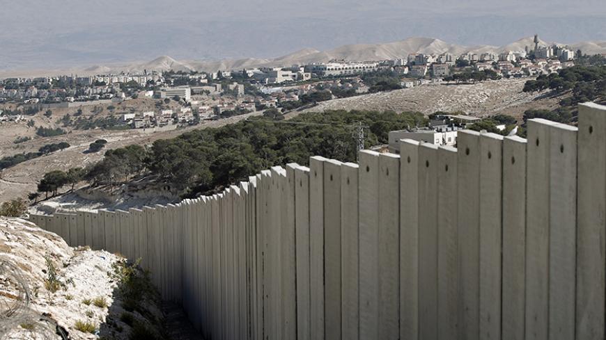 A picture taken on October 21, 2014 in the West Bank village of Zayem near Jerusalem, shows the Israel's controversial separation barrier with the Jewish settlement of Maale Adumim in the background.  AFP PHOTO/AHMAD GHARABLI        (Photo credit should read AHMAD GHARABLI/AFP/Getty Images)