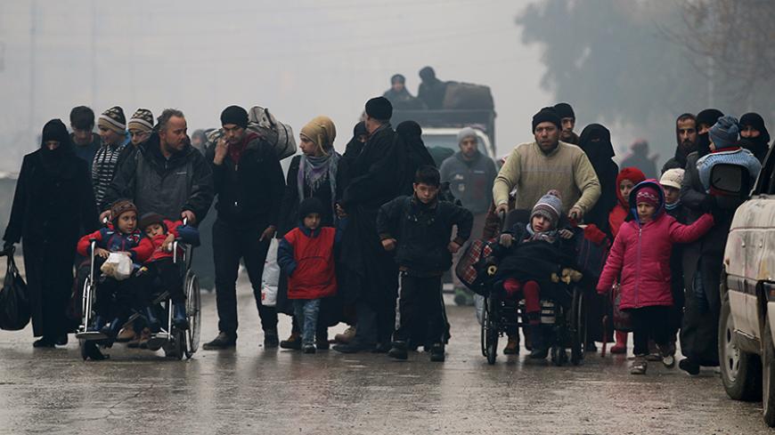 People walk as they flee deeper into the remaining rebel-held areas of Aleppo, Syria December 13, 2016. REUTERS/Abdalrhman Ismail - RTX2UUVR