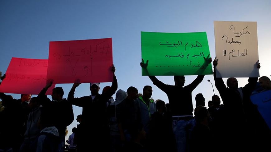 Israeli Arabs hold posters to protest against the demolishing of their houses by Israeli bulldozers in the northern Israeli city of Qalansuwa, January 11, 2017.  REUTERS/Ammar Awad - RTX2YJ68