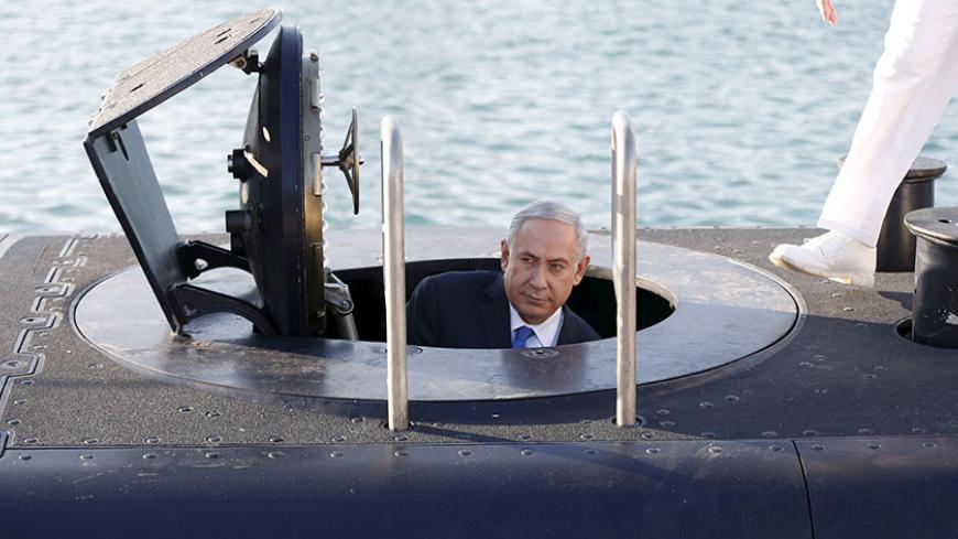 Israeli Prime Minister Benjamin Netanyahu climbs out after a visit inside the Rahav, the fifth submarine in the fleet, after it arrived in Haifa port January 12, 2016. The Dolphin-class submarines, widely believed to be capable of firing nuclear missiles, were manufactured in Germany and sold to Israel at deep discounts as part of Berlin's commitment to shoring up the security of the country set in part as a haven for Jews who survived the Holocaust.REUTERS/Baz Ratner - RTX221FU