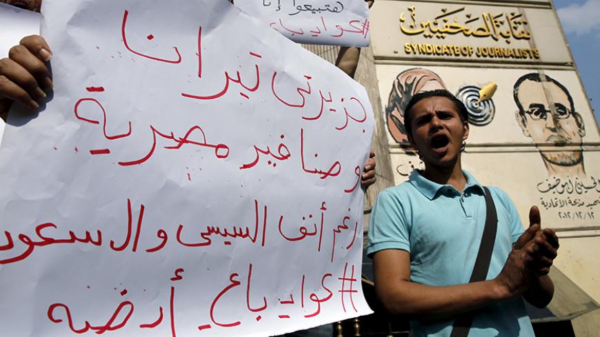 Egyptian activists shout anti-President Abdel Fattah al-Sisi and government slogans during a demonstration protesting against the government's decision to transfer two Red Sea islands to Saudi Arabia, in front of the Press Syndicate in Cairo, Egypt, April 13, 2016. The sign reads, "The two Islands Tiran and Sanafir are the Egyptians". REUTERS/Amr Abdallah Dalsh - RTX29RVO