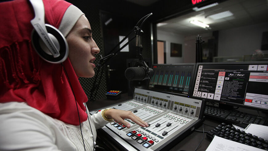 TO GO WITH AFP STORY BY HOSSAM EZZEDINE
Palestinian radio presenter Nora Abdul Hadi works at Nisaa FM radio station in the West Bank city of Ramallah on November 4, 2012. The crew of Nisaa (Women) FM, which was established in 2010 and addresses Palestinian women, aims to reach the Gaza Strip and all of the Arab world. AFP PHOTO/ABBAS MOMANI        (Photo credit should read ABBAS MOMANI/AFP/Getty Images)
