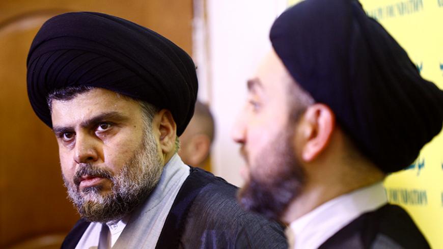 Iraqi Shiite cleric Moqtada al-Sadr (L) meets with Ammar al-Hakim (R), the leader of Iraq's Shiite Muslim Supreme Iraqi Islamic Council (SIIC), on August 28, 2014 at the latter's house in the holy city of Najaf. Iraq's most influential Shiite cleric Sadr had announced the creation of the Saraya al-Salam armed group, tasked with defending the holy sites of Shiite Islam, in the aftermath of the jihadist Sunni Muslim offensive that began in June 2014. AFP PHOTO / HAIDAR HAMDANI        (Photo credit should read